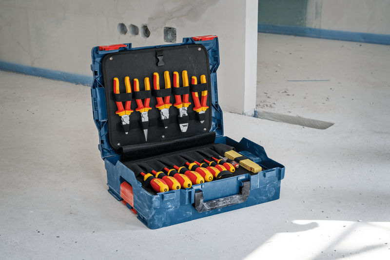 Elektriker-Werkzeug-Kombi-Set mit isolierten Schraubendrehern und Zangen in einem blauen Koffer. Anwendungsbild